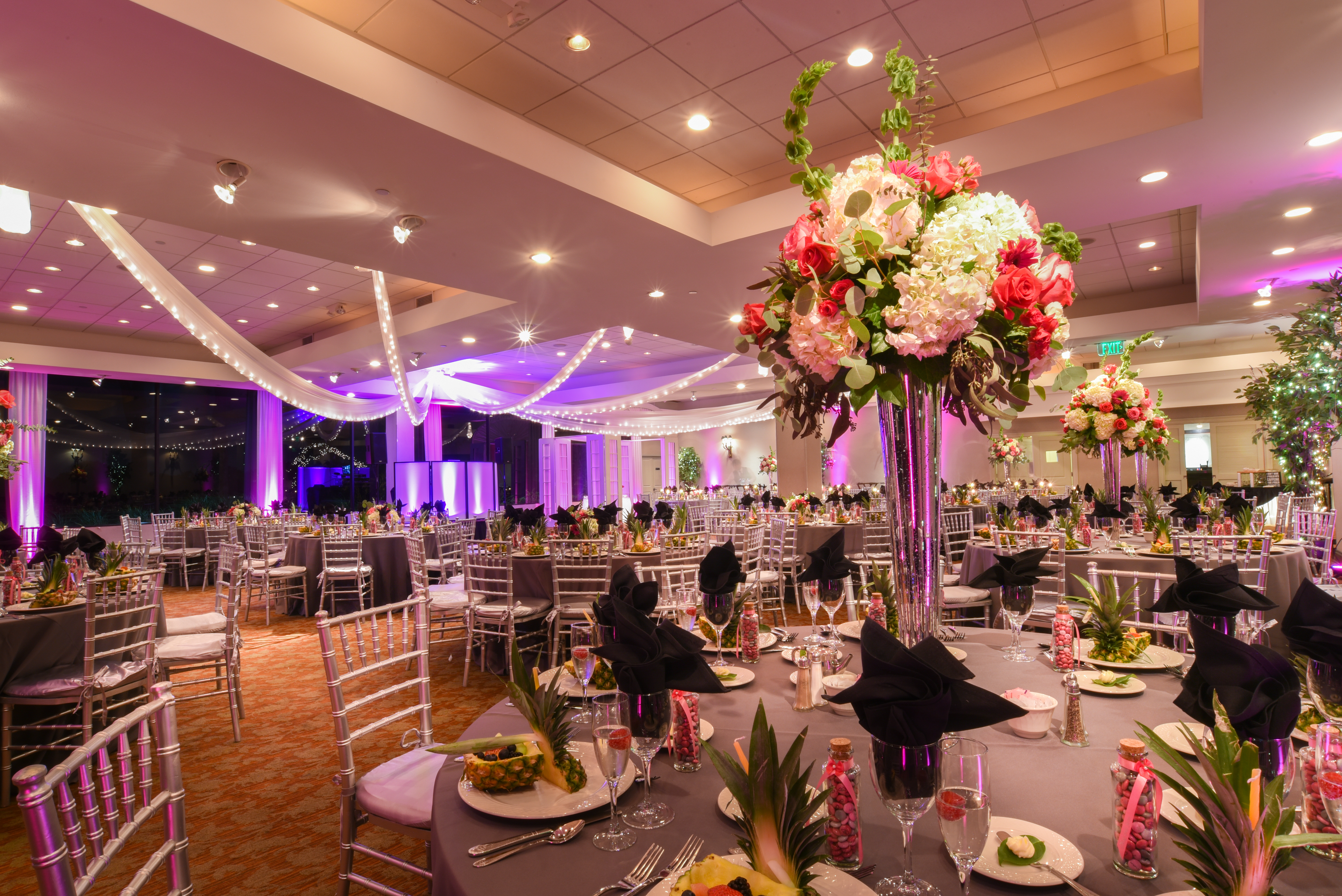 A dinning table decorated with flowers and fruits
