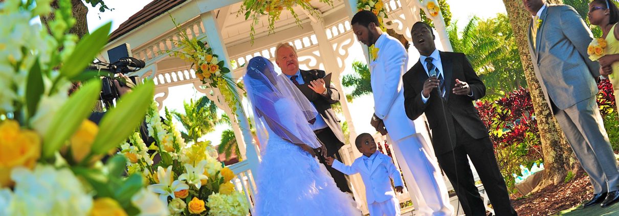 Outdoor wedding ceremony at a gazebo with bride, groom, and officiant