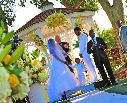 Outdoor wedding ceremony at a gazebo with bride, groom, and officiant