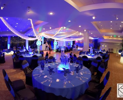 Ballroom decorated with blue uplighting and draping for an evening event